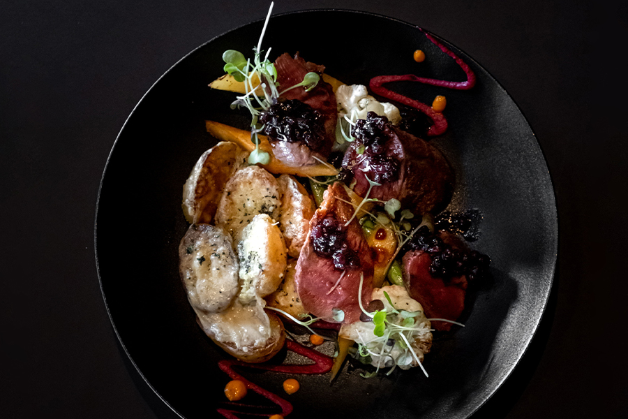 Loondocks Restaurant's Roasted Duck Breast with Wild Blueberry Gastrique, Parmesan Crusted Fingerlin